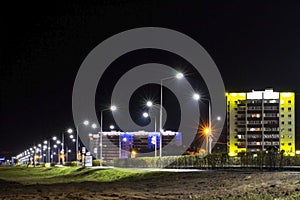 A deserted night road illuminated by led lights after rain in a provincial town