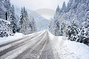 Deserted road covered in fresh snow in the mountains during a blizzard