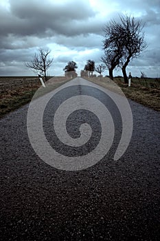 Deserted road under stormy sky photo