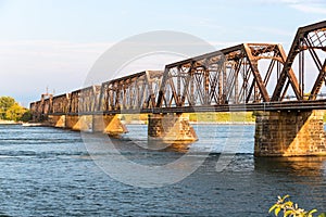 Deserted steel railway bridge accross a river