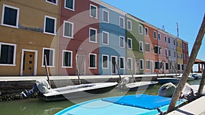 Deserted street of Burano island, colorful houses with closed windows, Venice