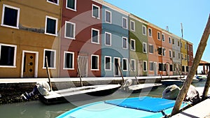 Deserted street of Burano island, colorful houses with closed windows, Venice