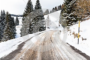 Deserted Winding Mountain Road Covered in Snow in Winter
