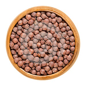 Desi chickpeas in wooden bowl over white photo