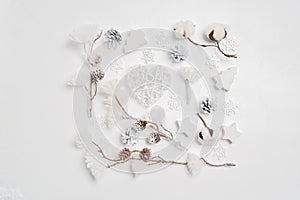 Design a Christmas greeting card with Xmas cones, heart, cotton flowers. Decorations on a white wooden background