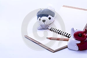 Design concept -  Blank diaries, a pencil and an eraser, along with a dog doll, a ceramic lover.