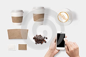 Design concept of mockup using smartphone and coffee set isolated on white background. Copy space for text and logo.