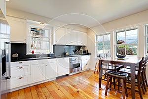 Design of kitchen room interior with white cabinets and black counter tops