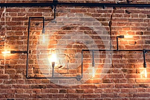 Design of vintage wall. Rustic design, brick wall with light bulbs and pipes, low lit bar interior