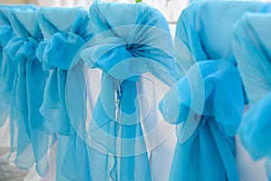 Design of wedding chairs with blue bows.