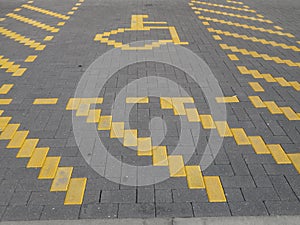 A designated handicap parking space outline in yellow brickwork