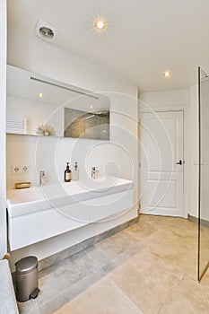 Designer bathroom with beige tiled floor