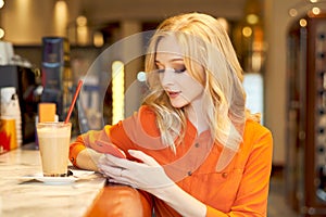 Young girl working for mobile phone sitting at bar