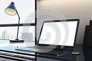 Designer desktop with blank white laptop screen