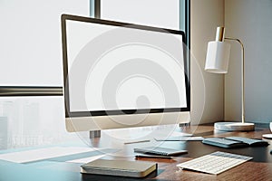 Designer desktop with empty white computer screen