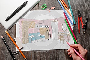 Designer drawing a girl`s room sketch on a paper sheet
