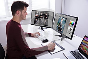 Designer Drawing On Graphic Tablet While Working On Computer