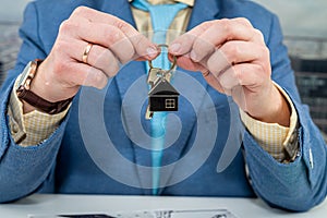 designer holds in his hands the keys that were given to him to design a house in new building.