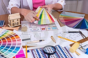 Designer`s hands showing colourful sampler at workplace