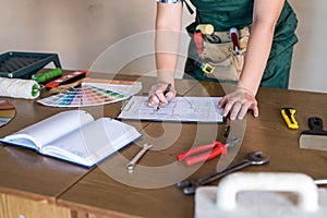 Designer`s working place with house plan, colour sampler and tools