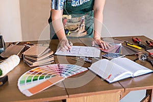 Designer`s working place with house plan, colour sampler and tools