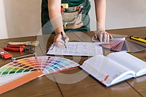 Designer`s working place with house plan, colour sampler and tools