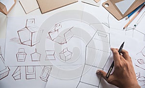 Designer sketching drawing design Brown craft cardboard paper product eco packaging mockup box development template package