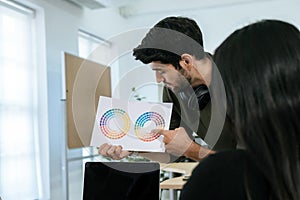 Designer. smart creative graphic designer man showing and working with color sample chart in meeting room