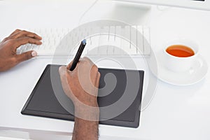 Designer using computer and digitizer with tea
