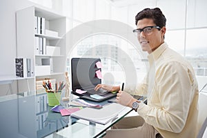 Designer using laptop and smiling at camera