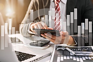 Designer using tablet with laptop and document on desk in modern office.