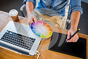 Designer working with colour wheel and digitizer