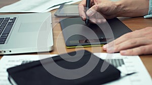 Designer working with graphics tablet, hands of man working with drawing tablet