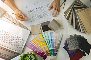 designer working in office doing furniture and flooring material selection from samples for home interior design project photo