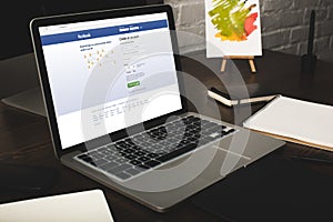 designer workplace with laptop and facebook website