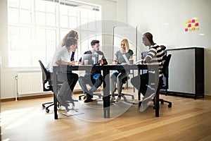 Designers discussing work together around an office table