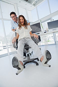 Designers having fun with on a swivel chair photo