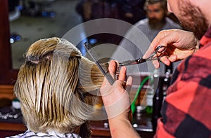 Designing haircut. barber tools in barbershop. handsome hairdresser cutting hair of male client. Hairstylist serving