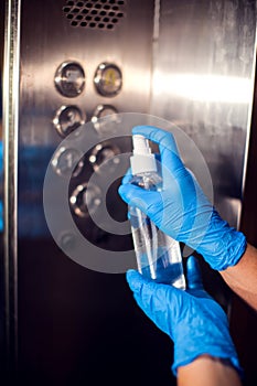 Desinfection of buttons in the elevator with antiseptic spray. Hygiene and virus protection concept