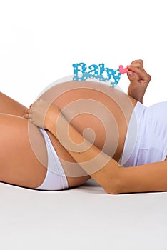 Desired pregnancy. Pregnant belly with blue label for newborn baby boy.