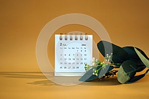 Desk calendar for February 2024 on a gold background
