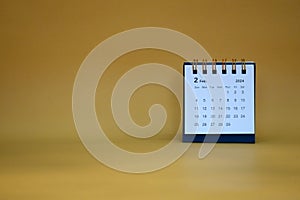 Desk calendar for February 2024 on a gold background