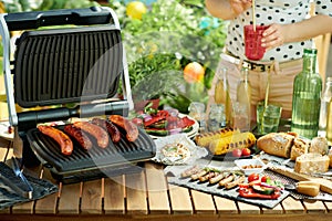 Desk with electric grill and grilled sausages