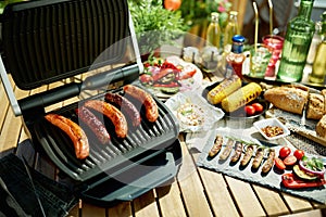 Desk with electric grill and grilled sausages