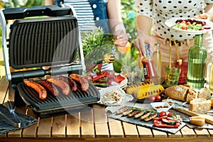 Desk with electric grill and grilled sausages