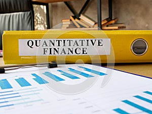 Desk with folder quantitative finance on it. photo