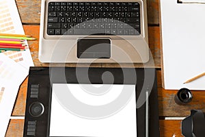 desk of graphic designer at work - digital tablet, computer, col