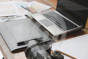 desk of graphic designer at work - digital tablet, computer, col