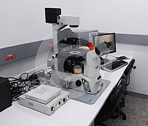 Desk with a high-tech microscopy station, fluorescence microscope, in laboratory