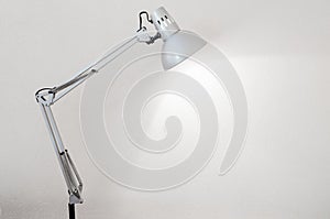 Desk lamp illuminating a white concrete wall